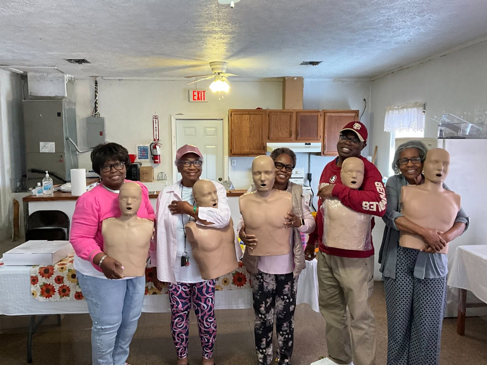 Breathe Again CPR students smiling and holding adult CPR manikins after class.