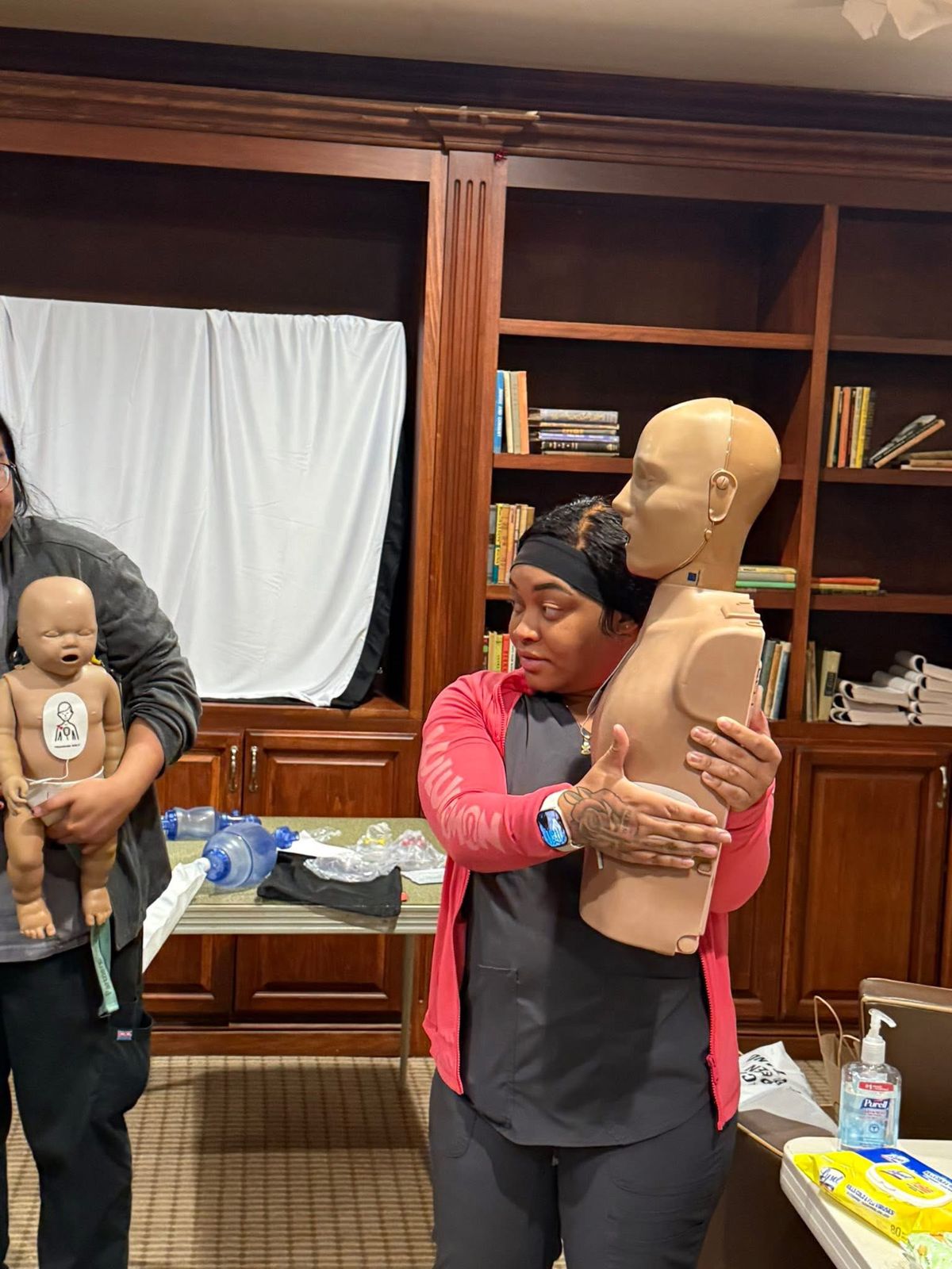 A student practicing choking relief on an adult manikin.