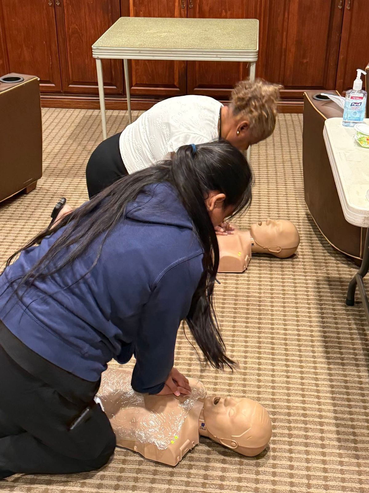 Two students practicing compressions side by side.