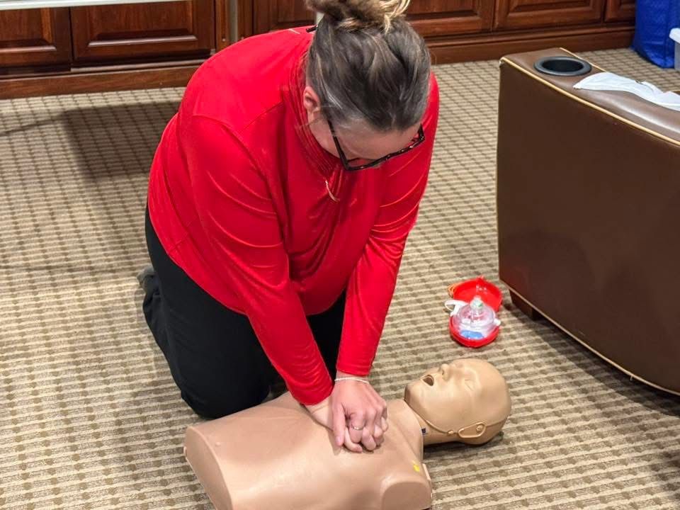 A student practicing chest compressions on an adult manikin.